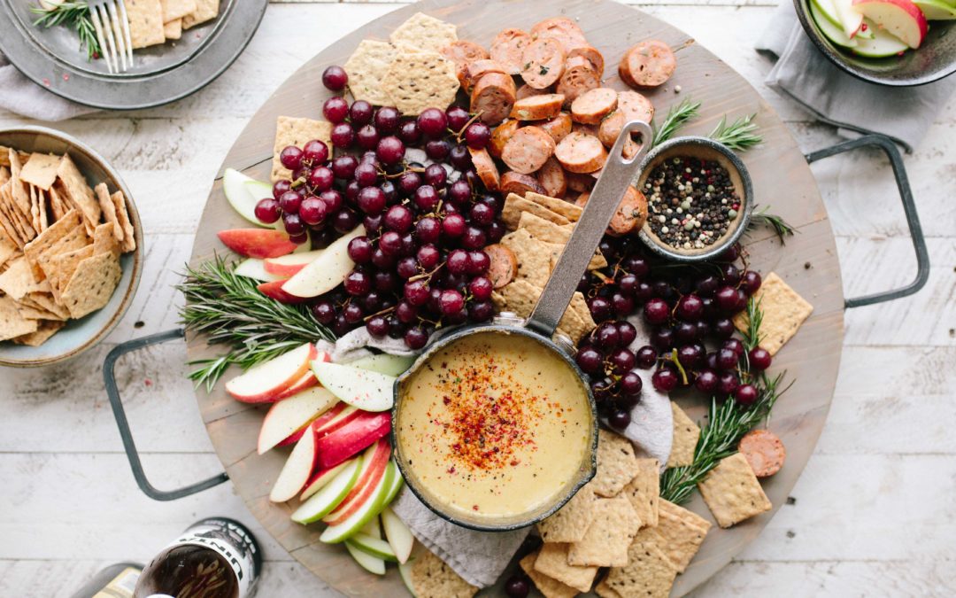 A round platter with various fruits, crackers and cheeses. Many of these foods can support our mental health. Image from Unsplash.