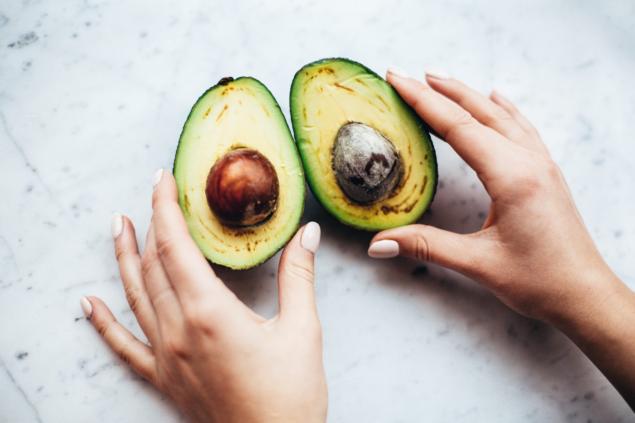 Avocado cut in half. Avocados are a great source of healthy fats but can be high in calories. Image from Pexels.