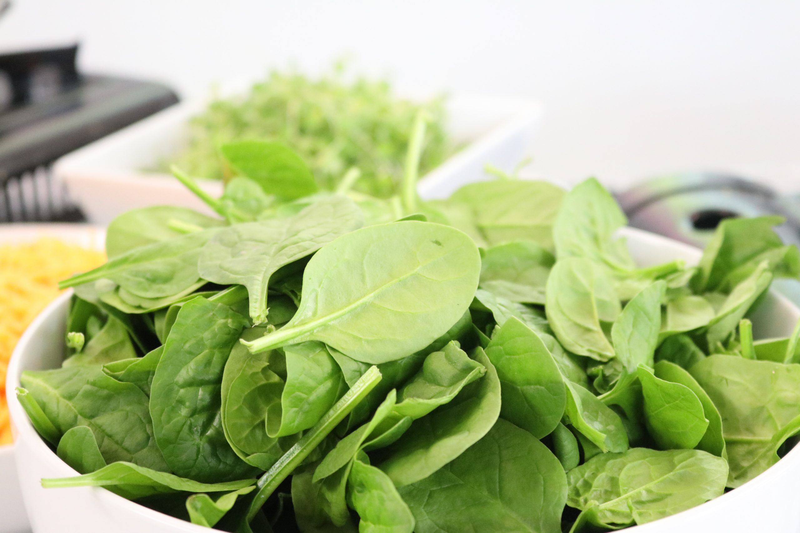 Bowl of spinach leaves. Spinach leaves are a great source of folate and can reduce our risk of folate deficiency anemia
