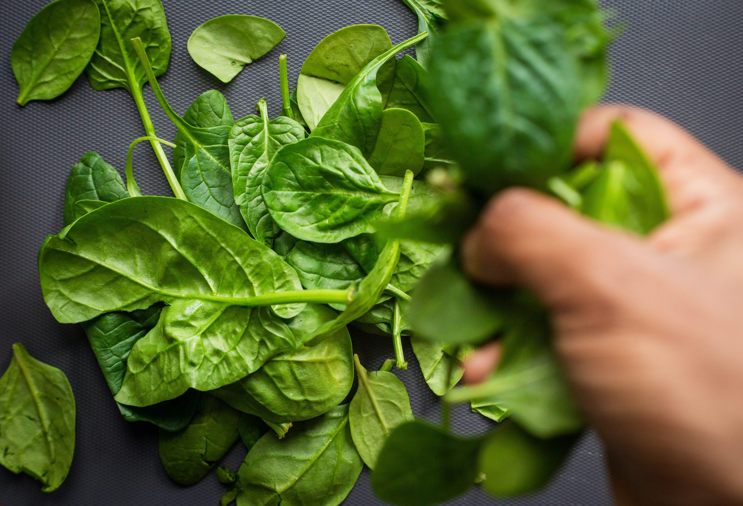Pile of spinach leaves. Spinach is rich in vitamin E, which supports brain health and function. Image from Unsplash.