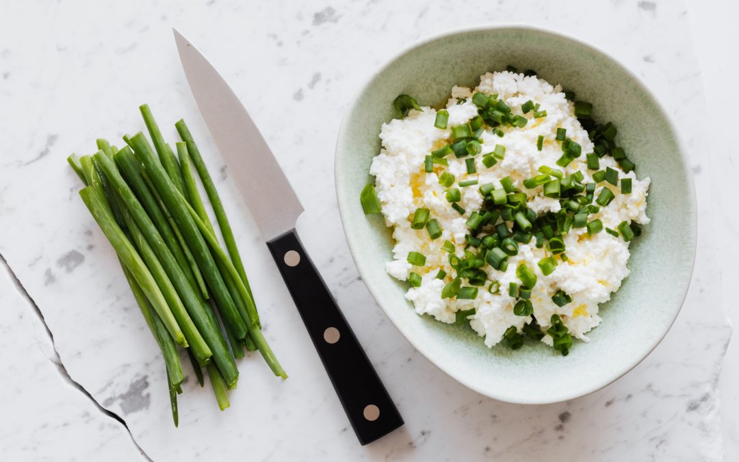 Cottage cheese in a bowl with chives. Cottage cheese contains selenium.
